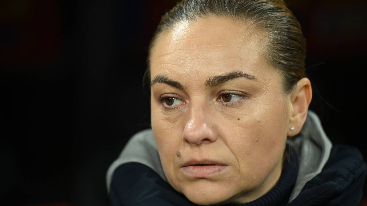 Portret kobiety w sportowej bluzie, patrzącej w bok ze skupionym wyrazem twarzy.