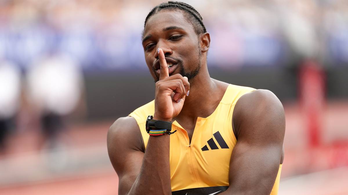 Portret lekkoatlety Noaha Lylesa w żółtej koszulce z trzema paskami, z palcem przy ustach.