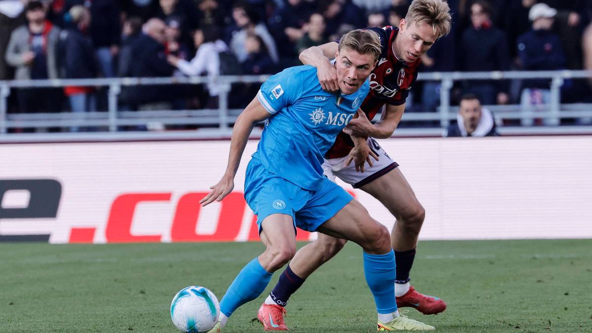 Dwóch piłkarzy walczących o piłkę na boisku piłkarskim.