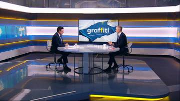Dw&oacute;ch mężczyzn siedzi przy stole w studiu telewizyjnym, podczas wywiadu w programie "Graffiti".