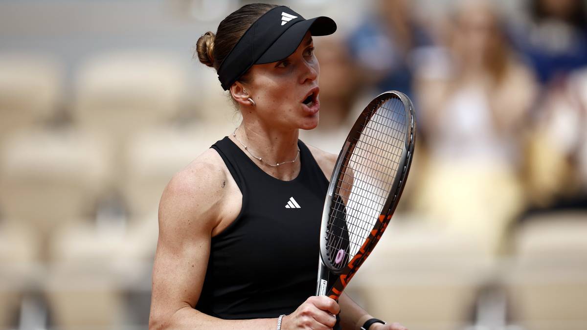 Tenisistka z zamkniętymi oczami i ustami otwartymi w geście wysiłku podczas meczu tenisowego. Ma na sobie czarną koszulkę, czarną czapkę z daszkiem i trzyma rakietę tenisową.