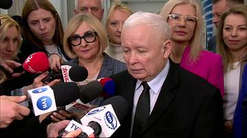 Jarosław Kaczyński przemawia do grupy dziennikarzy trzymających mikrofony.