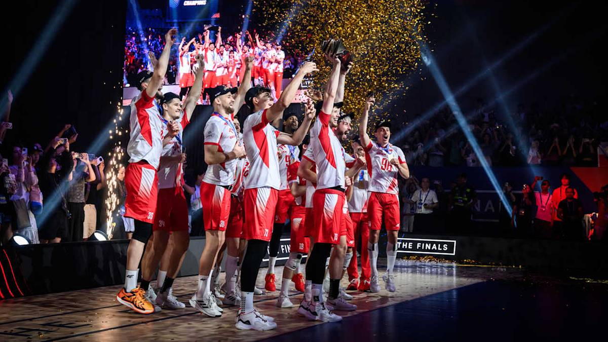 Siatkarze świętujący zwycięstwo na podium, obsypywani konfetti.