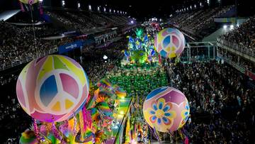 Nocna parada karnawałowa z kolorowymi balonami na pierwszym planie i tłumami widz&oacute;w.