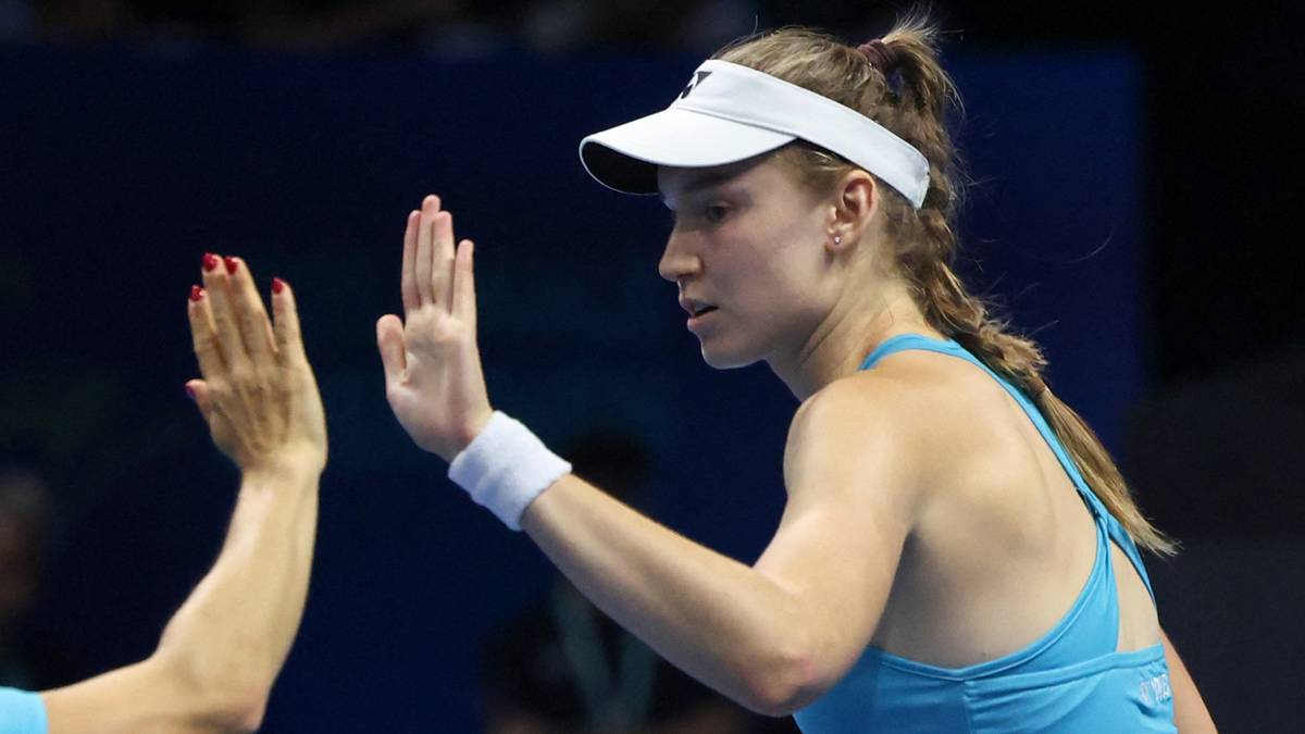 Tenisistka Elena Rybakina świętująca zwycięstwo, podając sobie "piątkę" z inną osobą.