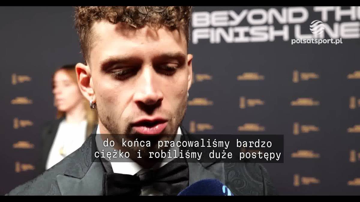 Marco Bezzecchi w garniturze i muszce mówi do mikrofonu.