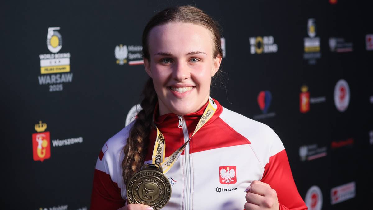 Uśmiechnięta zawodniczka boksu olimpijskiego w biało-czerwonym dresie z medalem na szyi.