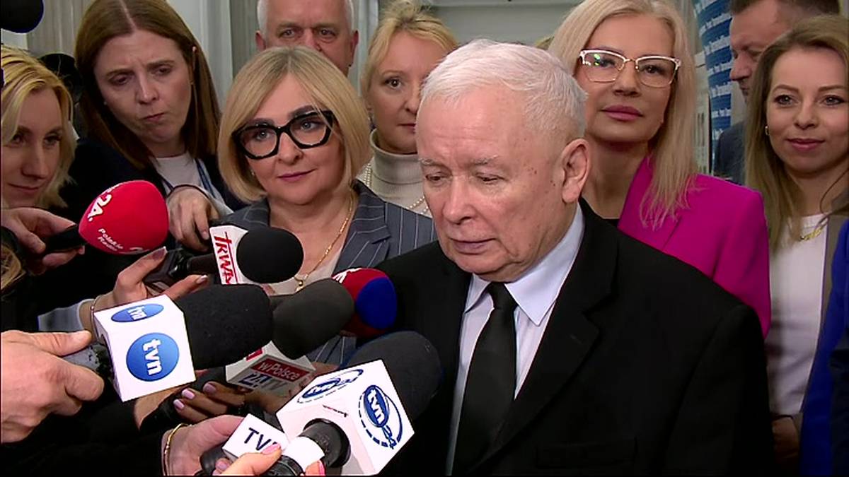 Jarosław Kaczyński przemawia do grupy dziennikarzy trzymających mikrofony.