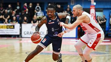 Dw&oacute;ch koszykarzy podczas meczu, jeden z nich prowadzi piłkę.