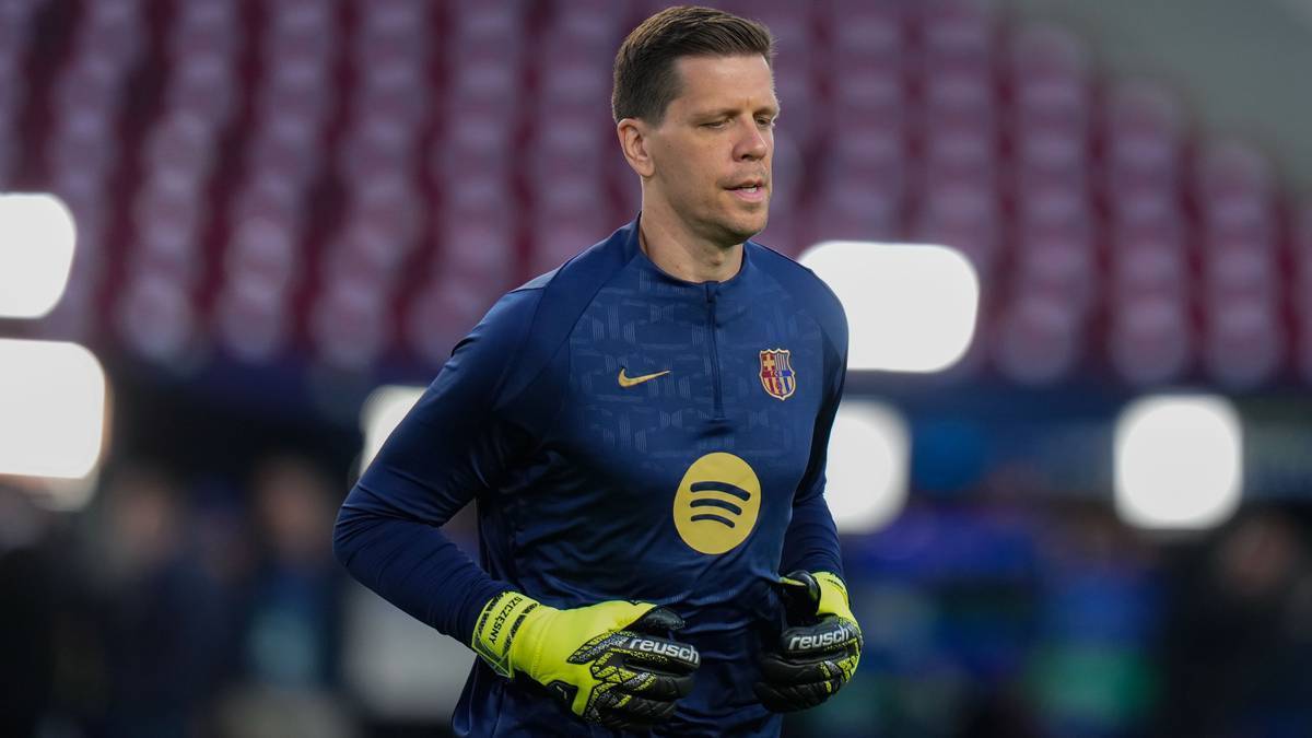 Piłkarz Wojciech Szczęsny, bramkarz FC Barcelony, w niebieskiej koszulce z żółtym symbolem Spotify na piersi i żółtymi rękawicami bramkarskimi, na tle trybun stadionu.