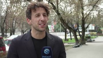 Filip Gawęcki, mężczyzna m&oacute;wiący do mikrofonu Polsat Sport, w tle drzewa.