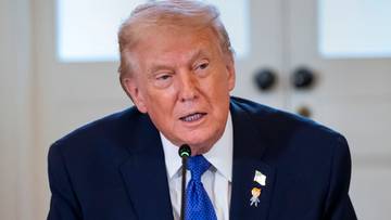 Donald Trump przemawiający do mikrofonu.