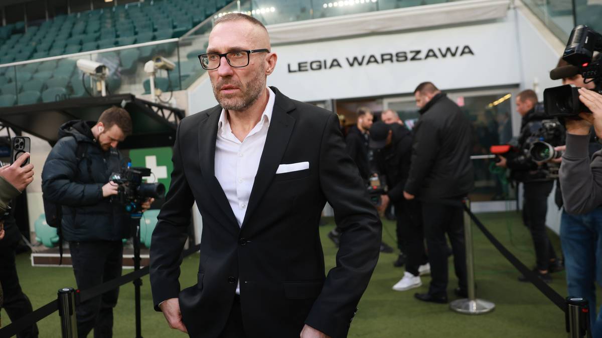 Mężczyzna w garniturze i okularach wychodzi z tunelu stadionu Legii Warszawa.