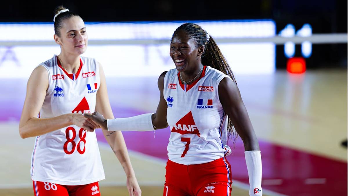 Dwie siatkarki w białych koszulkach z czerwonymi numerami na plecach (88 i 7) uśmiechają się do siebie i ściskają dłonie. Na koszulkach widoczne są francuskie barwy narodowe.