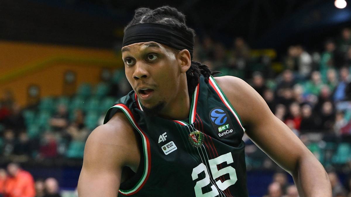 Koszykarz w zielonej koszulce z numerem 25 prowadzi piłkę.