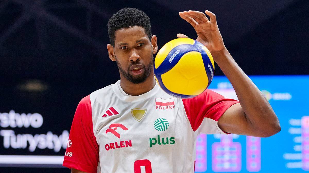 Portret Wilfredo Leona, siatkarza w biało-czerwonej koszulce, trzymającego piłkę siatkową.