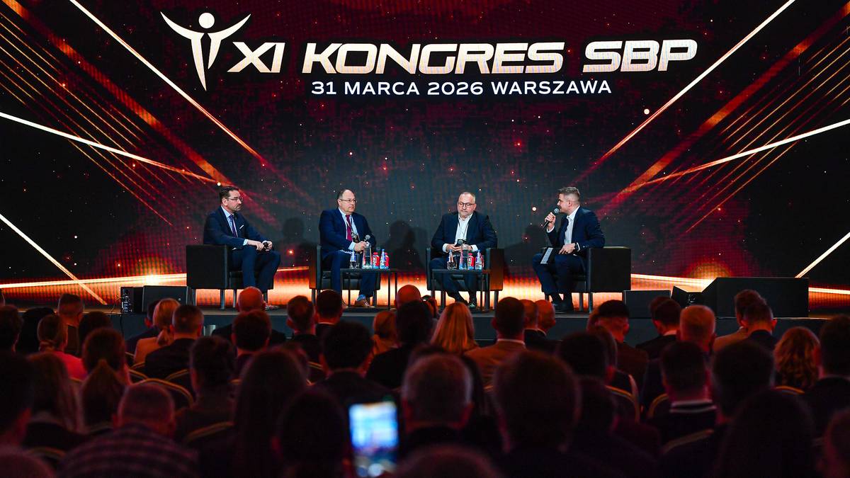 Czterech mężczyzn w garniturach siedzi na scenie podczas panelu dyskusyjnego na XI Kongresie Sport Biznes Polska.