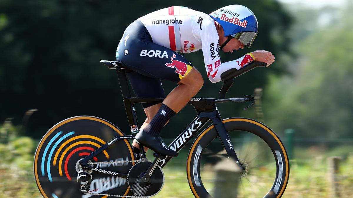 Kolarz w stroju wyścigowym ściga się na rowerze czasowym.