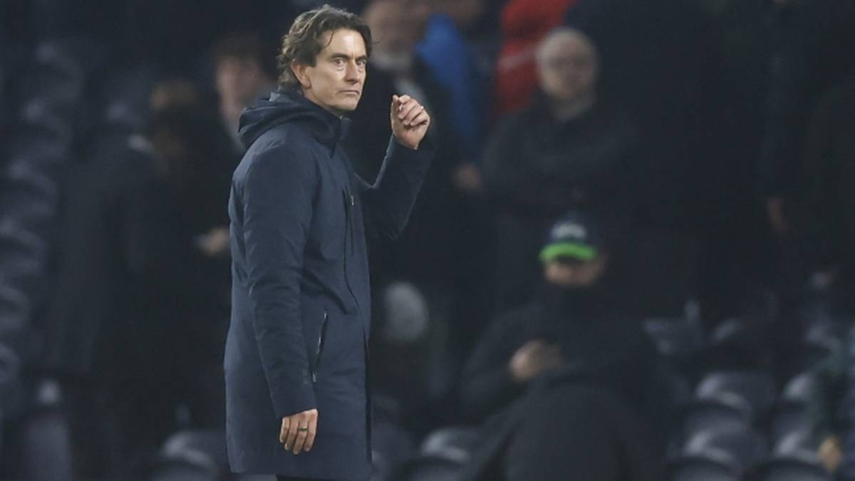 Trener Tottenhamu Thomas Frank wpatrzony w pole gry, ubrany w ciemną kurtkę.