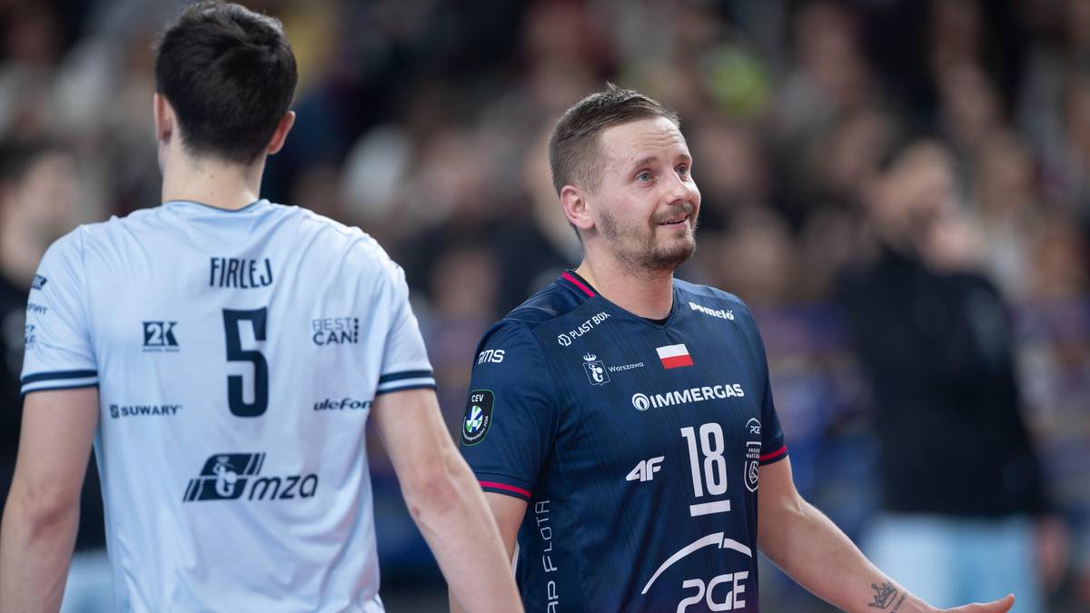 Dw&oacute;ch siatkarzy w strojach sportowych podczas meczu, jeden z nich jest zwr&oacute;cony tyłem i ma na koszulce numer 5, drugi jest zwr&oacute;cony przodem i ma na koszulce numer 18.