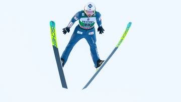 Skoczek narciarski w locie na nartach z tyczkami