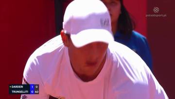 Gracz tenisa w białej koszulce i czapce z daszkiem, skupiony na grze.