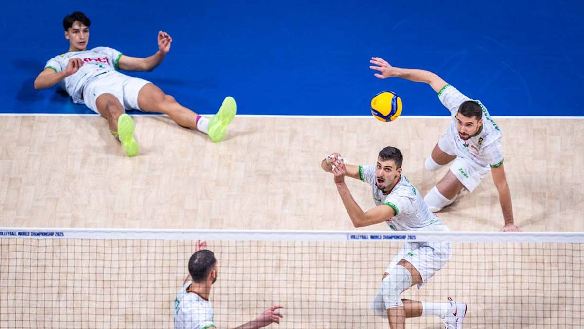 Siatkarze rywalizują na boisku podczas meczu siatkówki. Dwóch zawodników z jednej drużyny próbuje obronić piłkę, podczas gdy zawodnik z przeciwnej drużyny przygotowuje się do zagrania.