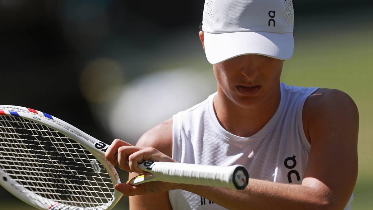 Iga Świątek przygotowuje rakietę tenisową podczas meczu Wimbledonu.