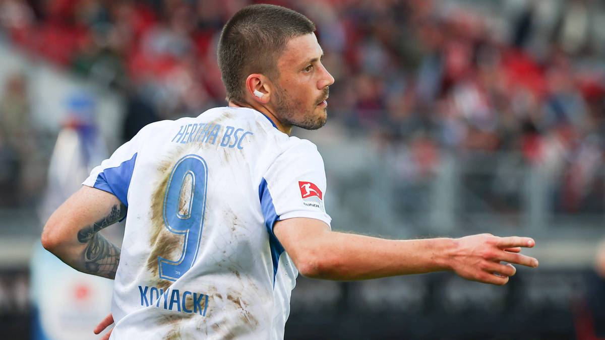 Piłkarz Dawid Kownacki w białej koszulce z numerem 9, patrzący w bok.