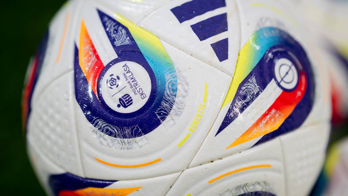 Zbliżenie na białą piłkę do piłki nożnej z kolorowymi elementami graficznymi i logo Ekstraklasy.