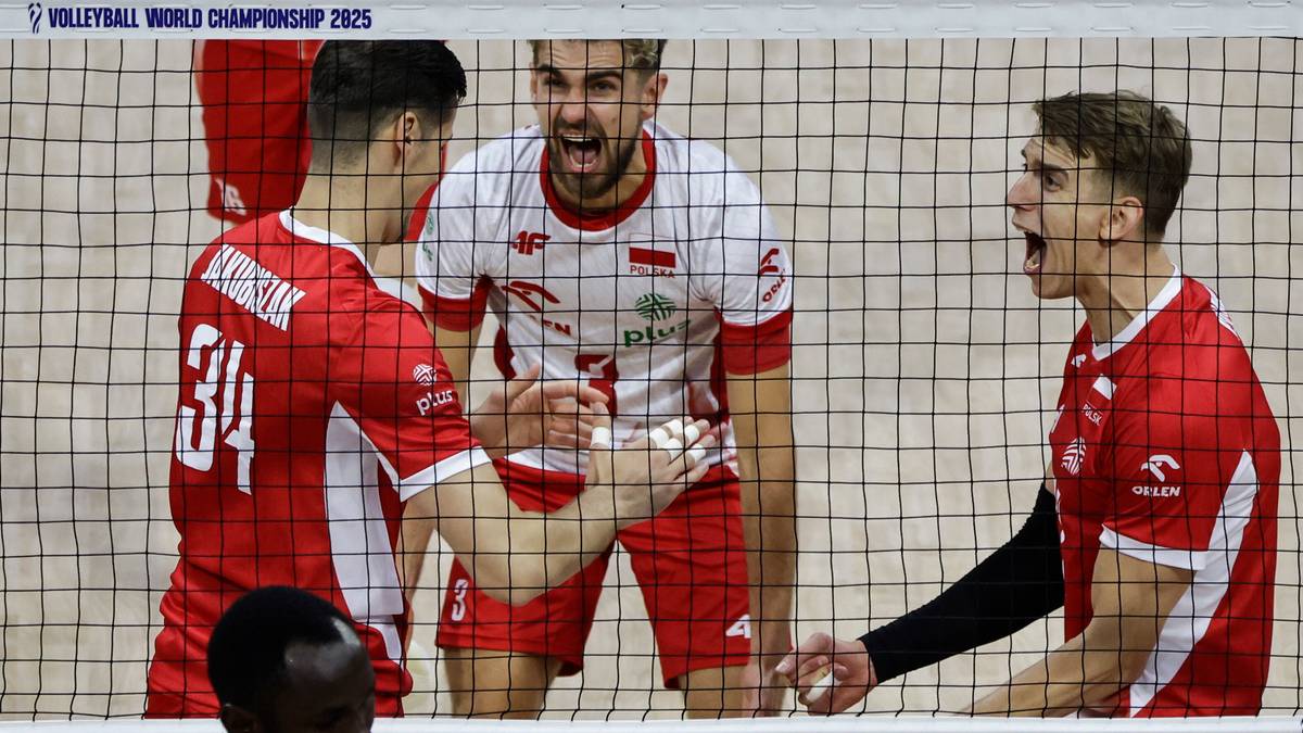 Trzej siatkarze w czerwonych koszulkach z białymi elementami świętują zwycięstwo. W środku jeden z nich trzyma rękę na brzuchu z wyrazem euforii na twarzy, pozostali dwaj krzyczą z radości.