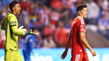 Piłkarz Robert Lewandowski w czerwonym stroju podczas meczu piłki nożnej.