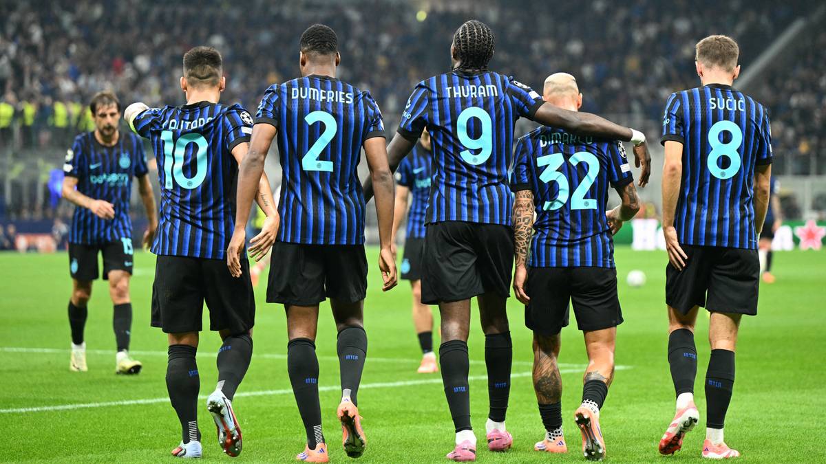 Piłkarze Interu Mediolan w niebiesko-czarnych strojach wychodzą na boisko w trakcie meczu.