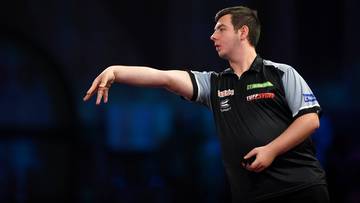 Darter rzuca lotką w kierunku tarczy.