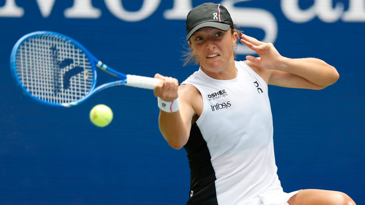 Iga Świątek podczas uderzenia piłki rakietą tenisową.