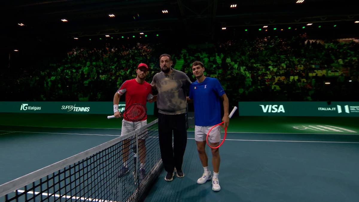 Trzech mężczyzn na korcie tenisowym, dwaj tenisiści i sędzia, po meczu.