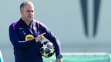 Trener Hansi Flick trzymający piłkę nożną podczas treningu.