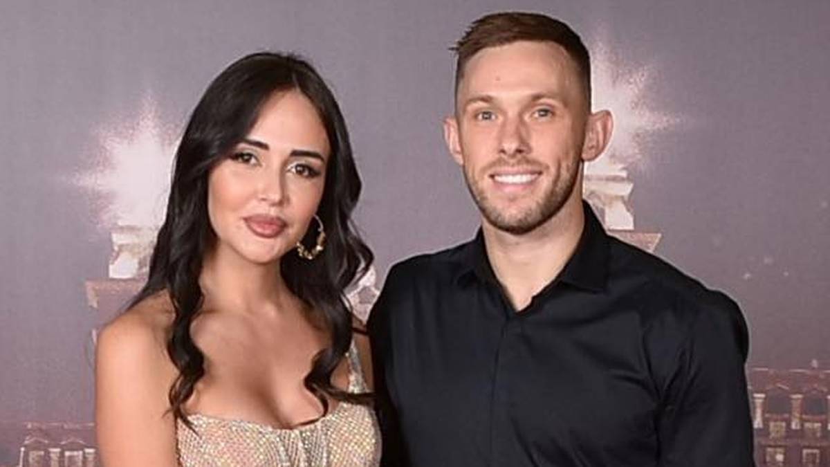 Para z dwoma synami pozuje do zdjęcia noworocznego z napisem "Happy New Year 2023" w tle.