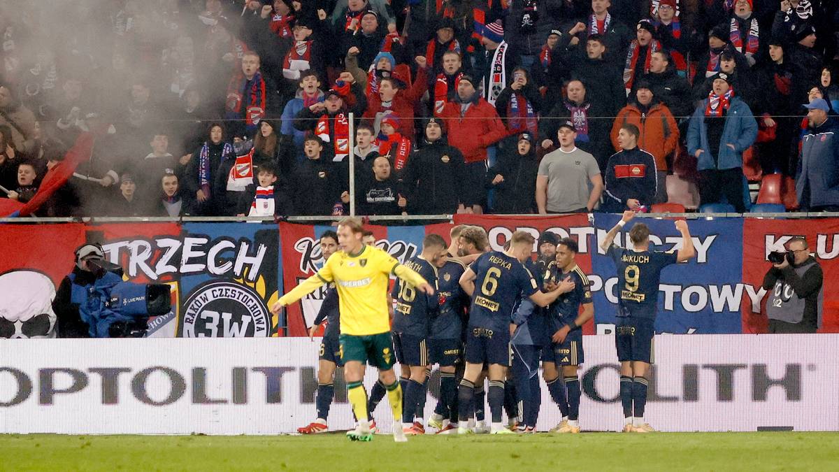 Piłkarze świętujący zdobycie bramki na tle trybun pełnych kibiców.