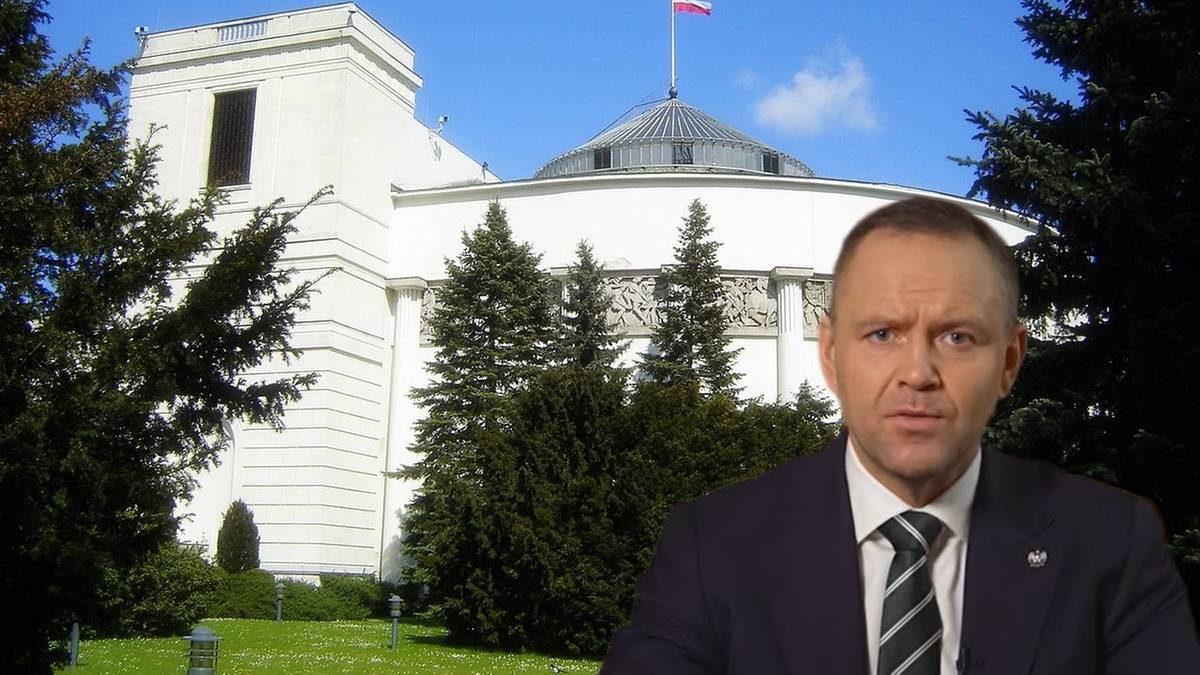 Mężczyzna w garniturze na tle budynku Sejmu.