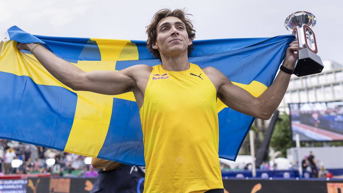 Armand Duplantis, lekkoatleta, w żółtej koszulce z flagą Szwecji na plecach, trzyma w prawej ręce trofeum.