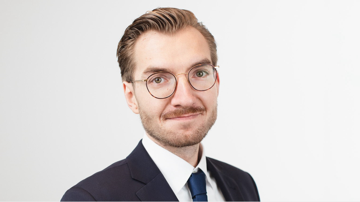 Marcin Fijołek w okularach i granatowym garniturze