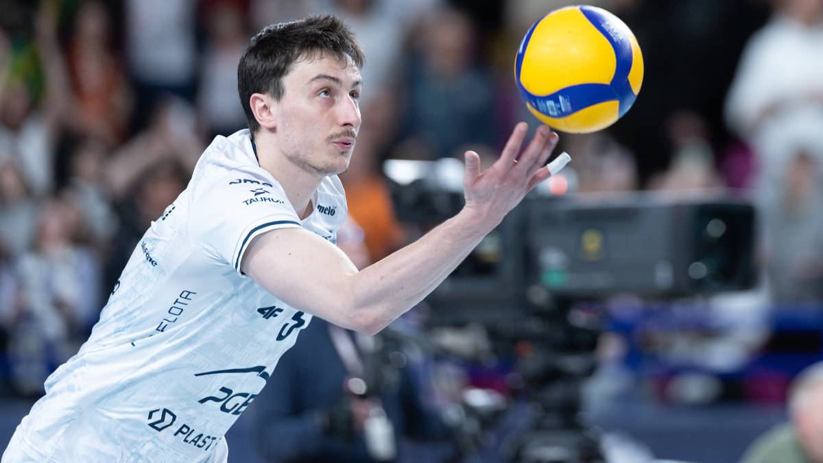 Siatkarz w akcji podczas meczu, przygotowujący się do zagrywki.