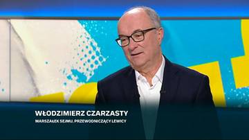 Włodzimierz Czarzasty, Marszałek Sejmu i przewodniczący Lewicy, ubrany w garnitur i białą koszulę, patrzy w bok i uśmiecha się. Na ekranie za nim widoczny jest niebiesko-biały wz&oacute;r.