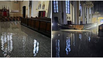 Zalane wnętrze kościoła z widocznymi odbiciami w wodzie na podłodze.