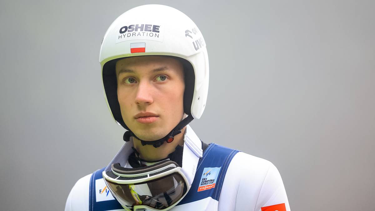 Portret młodego mężczyzny w kasku narciarskim, patrzącego prosto przed siebie.