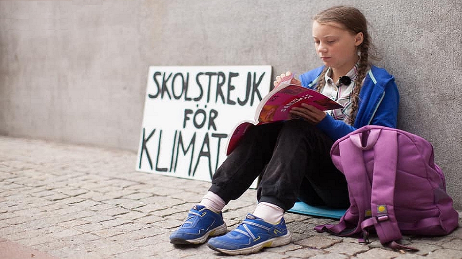 Greta Thunberg z transparentem „szkolny strajk dla klimatu”. Fot. Facebook / Greta Thunberg.