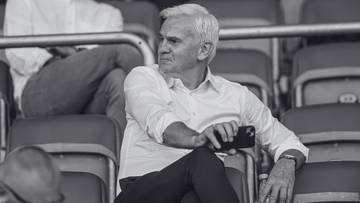 Mężczyzna siedzący na trybunach stadionu piłkarskiego.