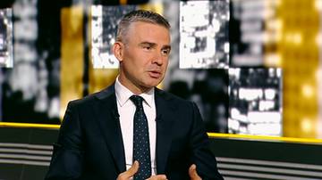 Dariusz Rosati w eleganckim garniturze i krawacie wypowiada się podczas wywiadu telewizyjnego.