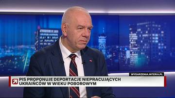 Jacek Sasin, ubrany w garnitur i krawat, siedzi w studiu telewizyjnym. Na ekranie za nim wyświetla się napis "PIS PROPONUJE DEPORTACJE NIEPRACUJĄCYCH UKRAIŃC&Oacute;W W WIEKU POBOROWYM".